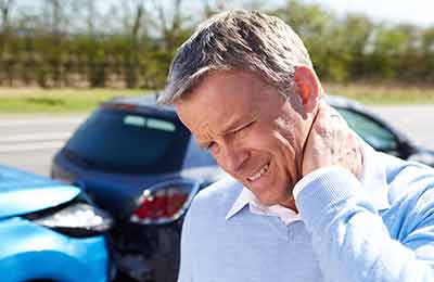 A man holding his neck in pain after a car accident. 